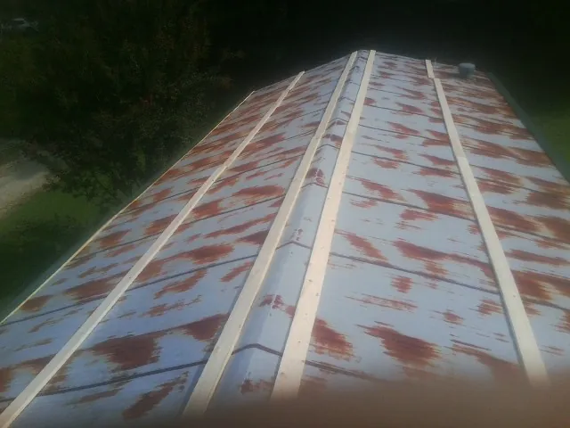 Rusted metal roof panels with new wood purlins before replacement — Storm Damage Roof Repair in Carbon by Roofing Brothers
