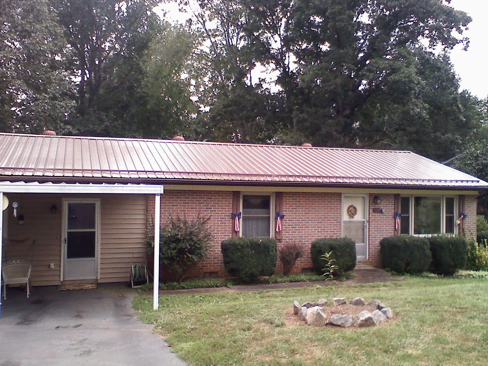 Bronze metal roof and carport on a brick ranch home — Roof Repair work by our crew in Carbon